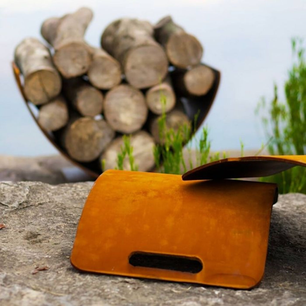 Modern carbon steel log rack with curved Wings of Flight design for stylish firewood storage