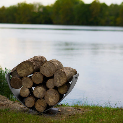 Modern stainless steel log rack with curved Wings of Flight design for stylish firewood storage